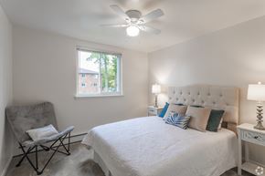 Newark apartment for rent - A bedroom with a white bed and a chair.