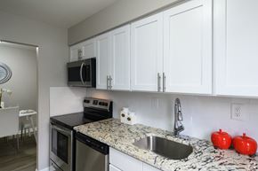 Newark apartment for rent - A kitchen with white cabinets and a granite countertop.