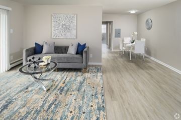 Newark apartment for rent - A living room with a grey couch and a blue rug.