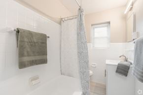 Allentown apartment for rent - A white bathroom with a shower curtain and a towel hanging on the towel rack.