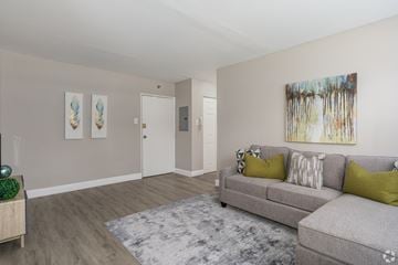 Barrington apartment for rent - A living room with a grey couch and a painting on the wall.