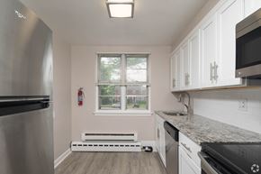 Pottstown apartment for rent - Renovated kitchen with a stainless steel refrigerator and white cabinets at Arbor Grove Apartments in Pottstown