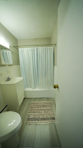 Philadelphia apartment for rent - A bathroom with a white toilet, sink, and a shower curtain.