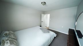 Philadelphia apartment for rent - A bedroom with a bed, nightstand, and mirror.