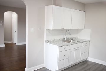 Philadelphia apartment for rent - A kitchen with white cabinets and a marble countertop.