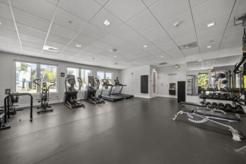 High end fitness center with cardio equipment, weights, and stretching area