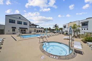 Spacious pool deck with heated pool & spa, cabana, bbq, and lounge seating