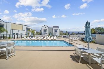 Spacious pool deck with heated pool & spa, cabana, bbq, and lounge seating