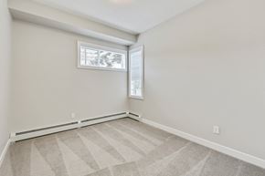 Calgary apartment for rent - an empty bedroom with a window and a carpeted floor