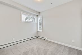 Calgary apartment for rent - an empty living room with two windows and white walls
