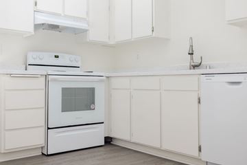 Cypress apartment for rent - A white kitchen with a white oven and microwave.