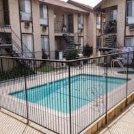 Anaheim apartment for rent - A black fence surrounds a small pool.