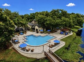 Tampa apartment for rent - A large outdoor swimming pool surrounded by a deck and lounge chairs.