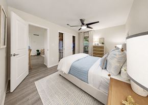 Tampa apartment for rent - A bedroom with a bed, dresser, and a ceiling fan.