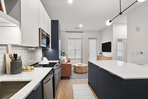 Charlotte apartment for rent - A modern kitchen with dark cabinets and a white countertop.