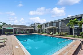 Tampa apartment for rent - A swimming pool surrounded by a fence and chairs.