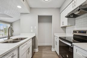 Tampa apartment for rent - A kitchen with white cabinets and a black stove top oven.