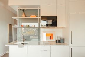 Atlanta apartment for rent - a white kitchen with white cabinets and a window at Scout Living, powered by Placemakr Apartments, Georgia