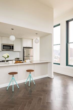 Pittsburgh apartment for rent - A kitchen with a white counter and two blue stools at The Pennsylvanian Apartments, Pittsburgh, Pennsylvania