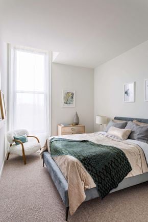 Pittsburgh apartment for rent - A bedroom with a bed, chair, and nightstand at The Pennsylvanian Apartments, Pennsylvania, 15222