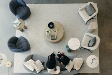 Salt Lake apartment for rent - Two people sitting on a grey couch in a living room with a coffee table and a grey pouf.