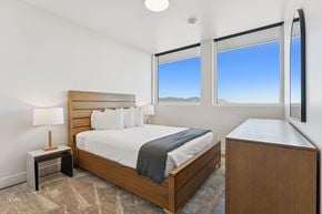 Salt Lake apartment for rent - A bedroom with a large bed and a nightstand with a lamp.