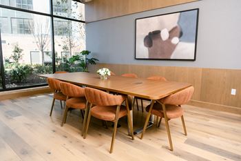 Long conference room with table and brown chairs