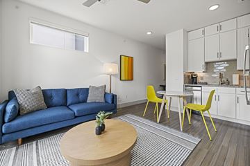 Austin apartment for rent - A living room with a blue couch and yellow chairs.