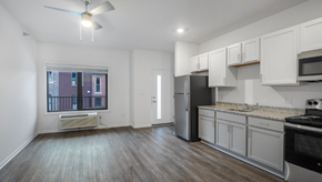 Detroit apartment for rent - A kitchen with white cabinets and a black stove top oven.