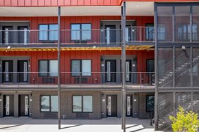 Detroit apartment for rent - A modern building with a red roof and balconies.