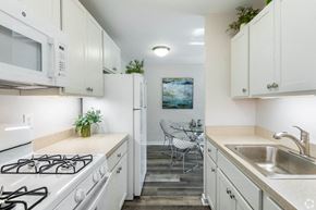 Wauwatosa apartment for rent - a kitchen with white cabinets and appliances and a sink