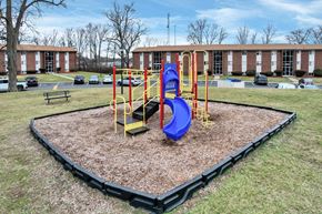 Indianapolis apartment for rent - A playground with a blue slide and yellow poles.