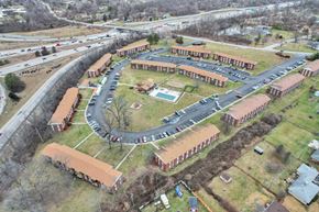 Indianapolis apartment for rent - A large building complex with a parking lot in front.