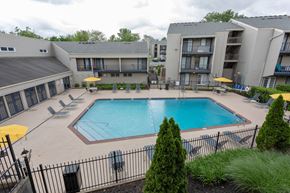 Lexington apartment for rent - A pool surrounded by a black fence and a building in the background.