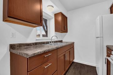 Indianapolis apartment for rent - A kitchen with brown cabinets and a granite countertop.