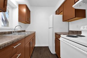 Indianapolis apartment for rent - A kitchen with brown cabinets and white appliances.
