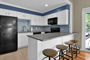 Indianapolis apartment for rent - a kitchen with a large island with four stools in front of it