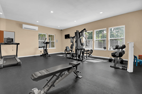 Indianapolis apartment for rent - A spacious home gym with a variety of equipment including treadmills, weights, and exercise machines.