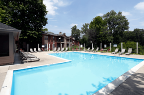 Indianapolis apartment for rent - A large swimming pool surrounded by chairs and trees.