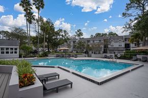 Jacksonville apartment for rent - A swimming pool surrounded by benches and trees.