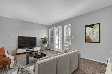 Indianapolis apartment for rent - A living room with a grey couch, a black television, and a painting on the wall.