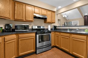 Indianapolis apartment for rent - A kitchen with wooden cabinets and a black countertop.