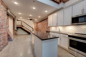 Knoxville apartment for rent - A kitchen with a brick wall and a ceiling fan.