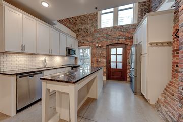Knoxville apartment for rent - A kitchen with white cabinets and a brick wall.