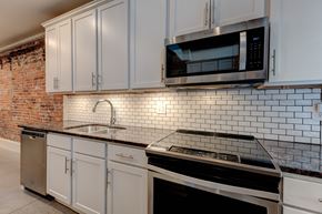 Knoxville apartment for rent - A kitchen with white cabinets and a black stove top oven.
