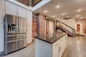 Knoxville apartment for rent - A kitchen with a stainless steel refrigerator and a brick wall.