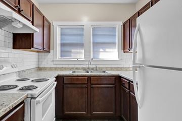 Knoxville apartment for rent - a kitchen with white appliances and brown cabinets