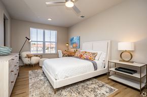 Louisville apartment for rent - A bedroom with a white bed, a white dresser, and a white rug.