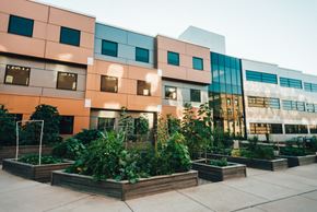 Grand Rapids apartment for rent - modern black and orange cubed building with community garden