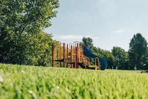 Rockford apartment for rent - playground surrounded by grass and trees